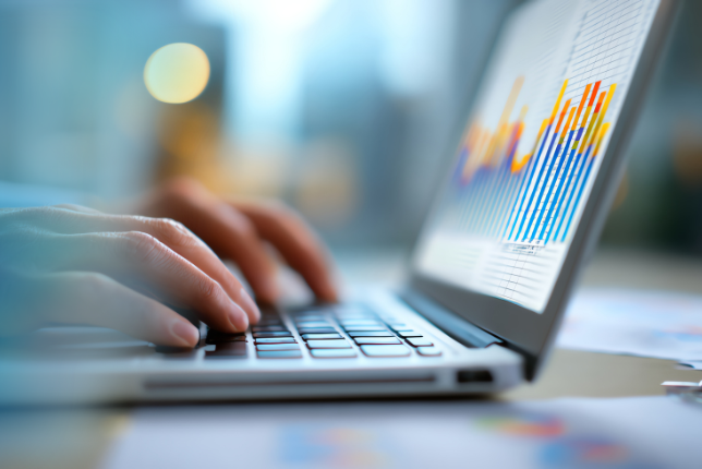 Person tippt auf Laptop, Statistiken zu sehen